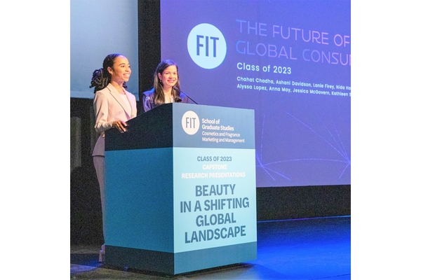 Two female students from FIT giving a presentation on their research.